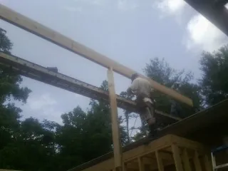 Carpenter setting a ridge beam over a new addition frame — Ice Dam Removal by Roofing Brothers in Cherry Hill