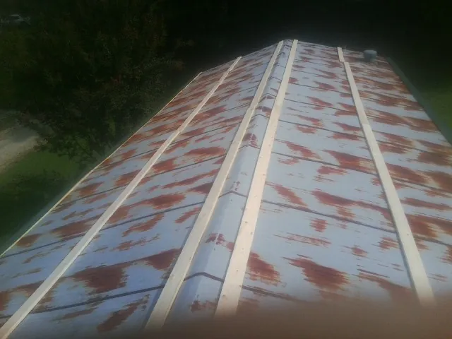 Rusted metal roof panels with new wood purlins before replacement — Storm Damage Roof Repair in Cherry Hill by Roofing Brothers