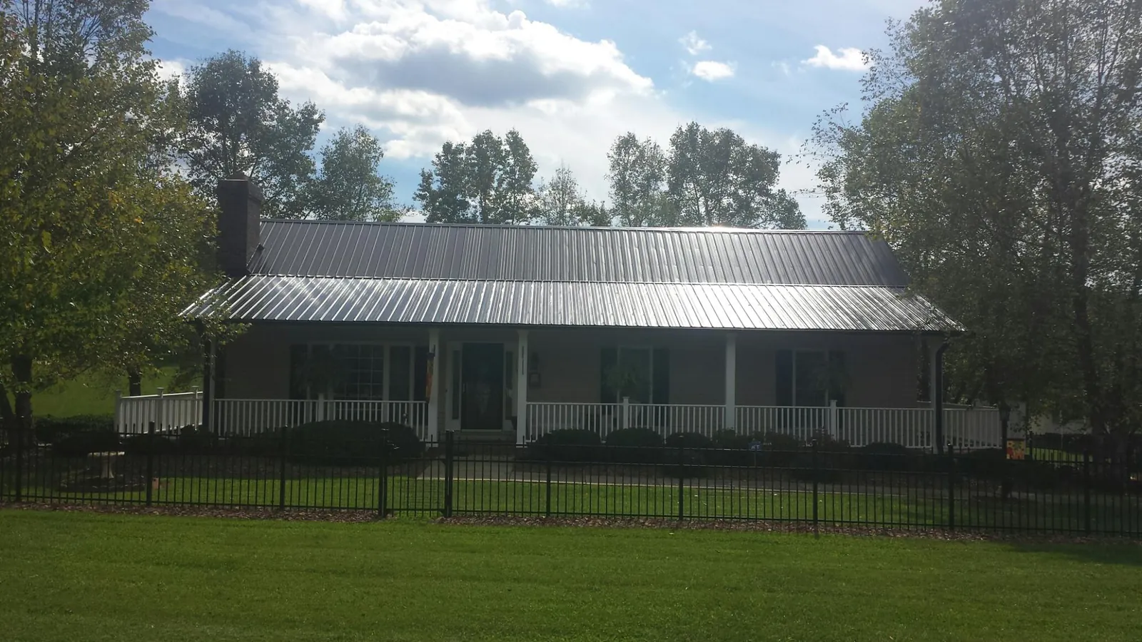 Gray metal roof on a brick ranch with a full width front porch — Gutter Guard Installation work by our crew in Cherry Hill