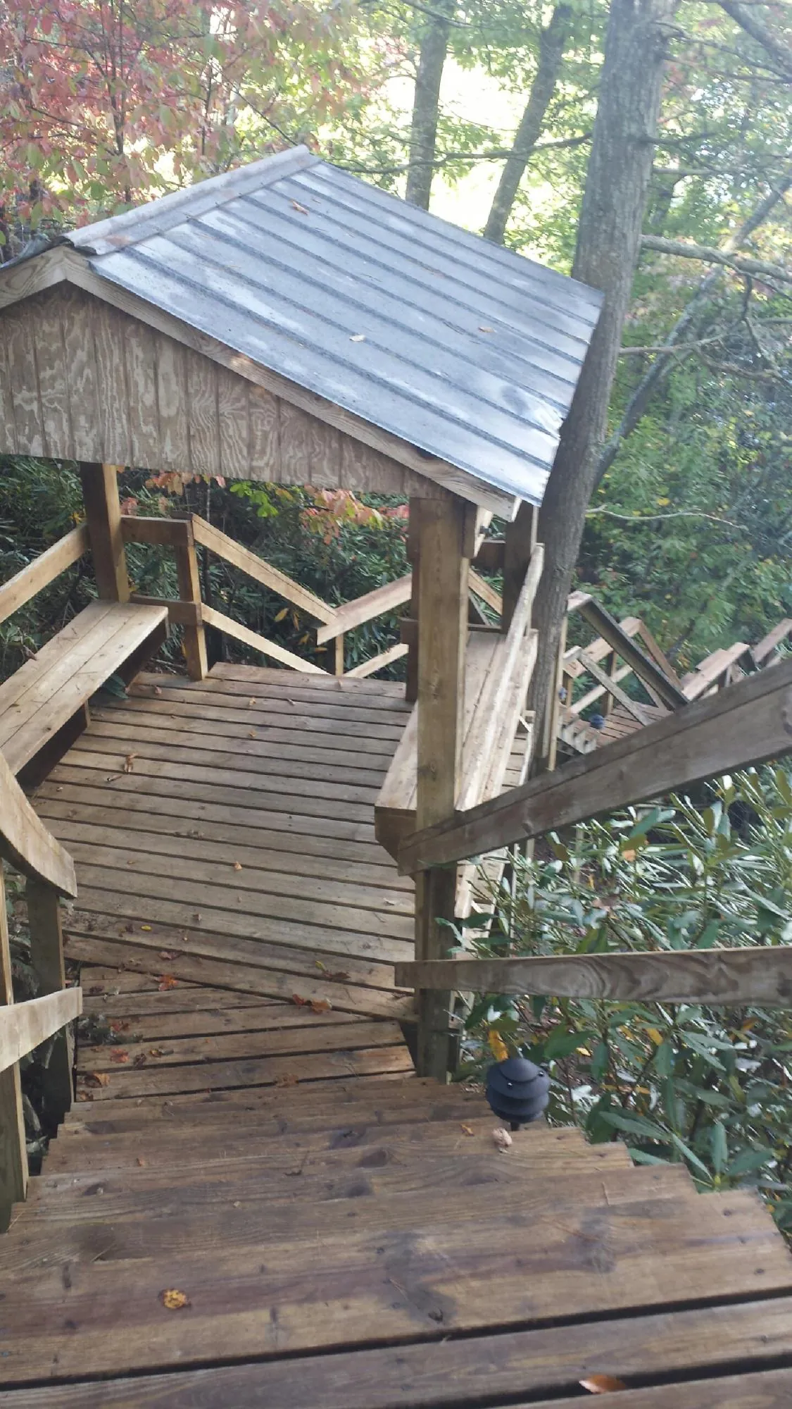 Metal roofed shelter over wooden steps on a wooded walkway — Skylight Repair & Installation work by our crew in Cherry Hill